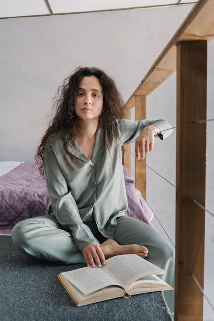 Woman practicing yoga gracefully indoors, in a space filled with soft light.